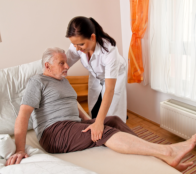Assisting elder male in bed